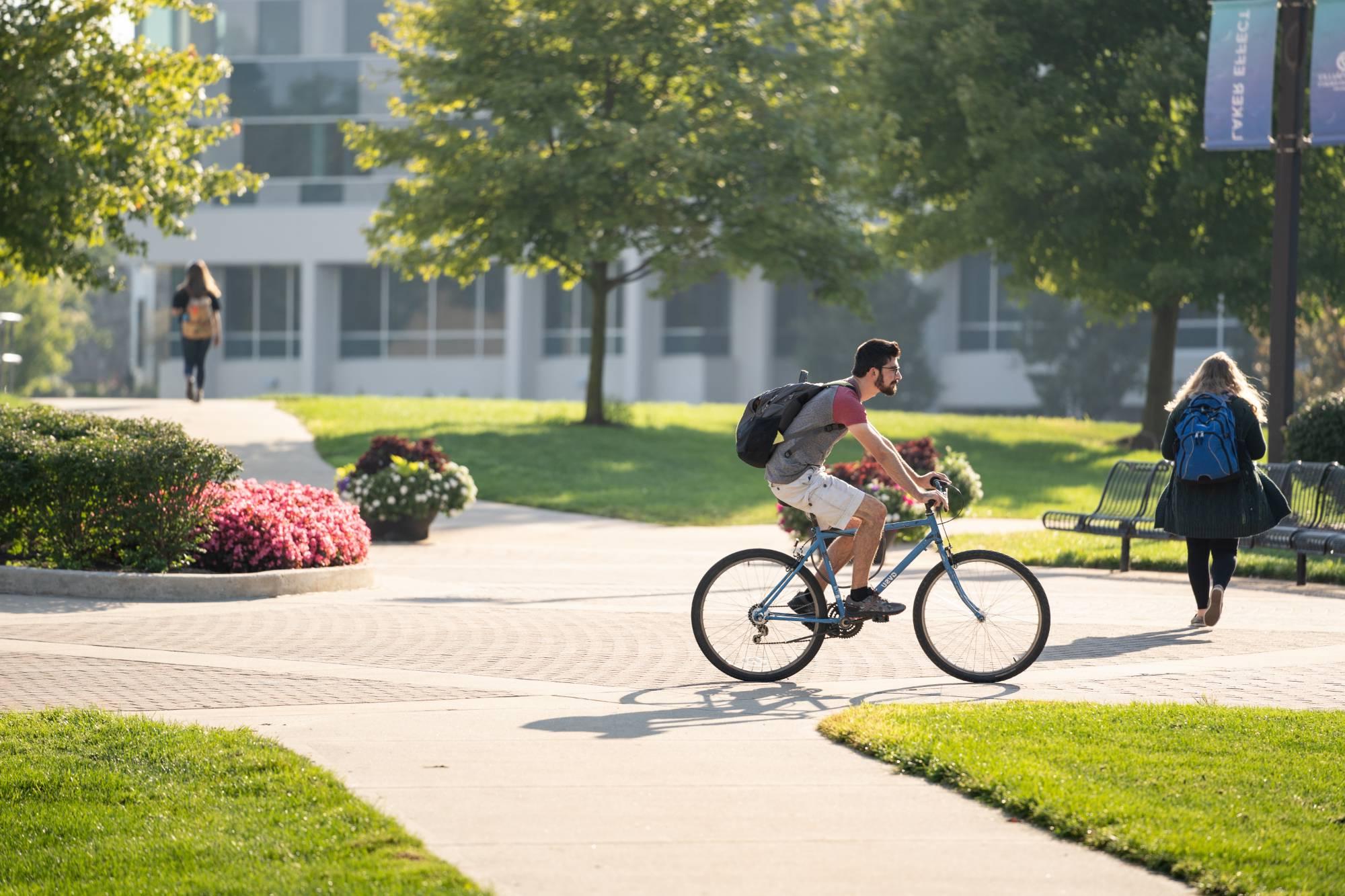 student bikes across campus